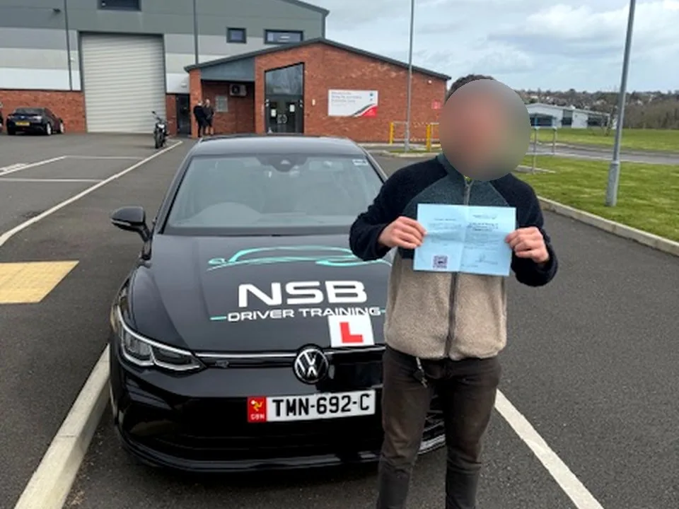 An anonymised NSB learner pass photo with the NSB Driver Training car outside the Isle of Man test centre
