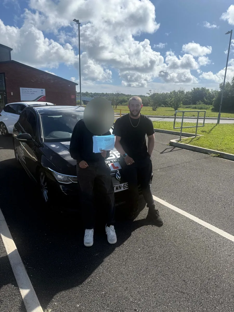 An anonymised learner and Nathan beside the NSB Driver Training car after a test-day success